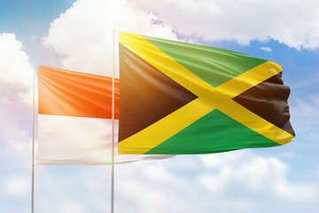 Sunny blue sky and flags of jamaica and indonesia