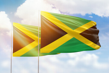 Sunny blue sky and flags of jamaica and jamaica - obrazy, fototapety, plakaty