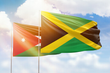 Sunny blue sky and flags of jamaica and jordan