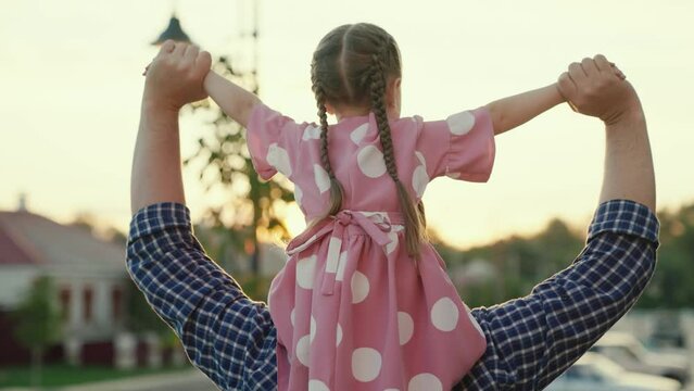 Friendship Concept Of Dad And Daughter. Dad Plays With His Daughter, Walks Along, City Street With His Beloved Child. Child And Parent. Father Walking With His Daughter On His Shoulders In Summer Park