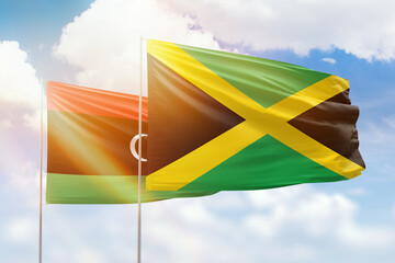 Sunny blue sky and flags of jamaica and libya
