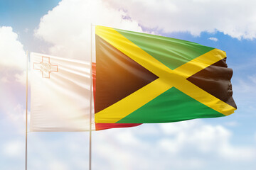 Sunny blue sky and flags of jamaica and malta