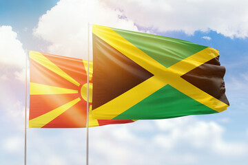 Sunny blue sky and flags of jamaica and north macedonia