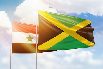 Sunny blue sky and flags of jamaica and syria