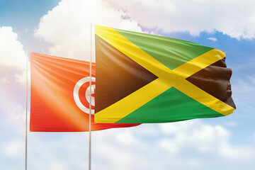 Sunny blue sky and flags of jamaica and tunisia