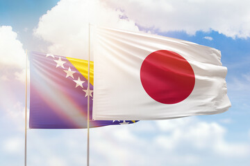 Sunny blue sky and flags of japan and bosnia