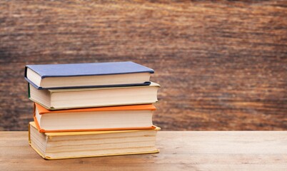 A pile of old books on wooden desk. Reading, library, education, ancient books, book club concept.