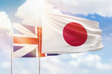 Sunny blue sky and flags of japan and great britain