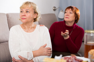 Quarrel between two senior women in home interior