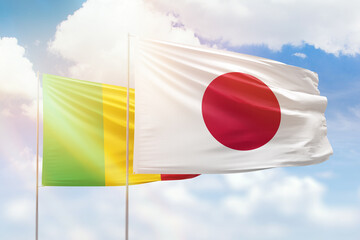 Sunny blue sky and flags of japan and mali