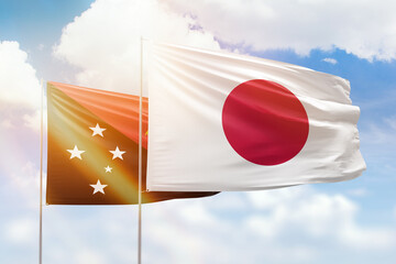 Sunny blue sky and flags of japan and papua new guinea