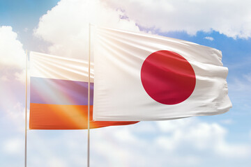 Sunny blue sky and flags of japan and russia