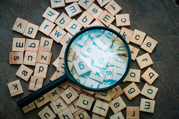 English alphabet made of square wooden tiles with the English alphabet scattered on wood background. The concept of thinking development,grammar.