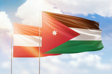 Sunny blue sky and flags of jordan and austria