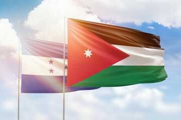 Sunny blue sky and flags of jordan and honduras