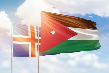 Sunny blue sky and flags of jordan and iceland