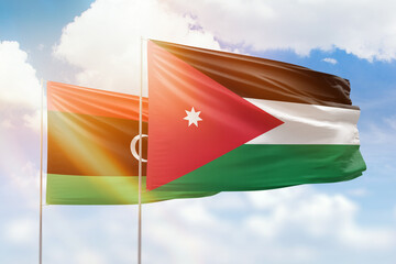 Sunny blue sky and flags of jordan and libya