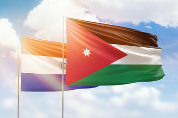 Sunny blue sky and flags of jordan and paraguay