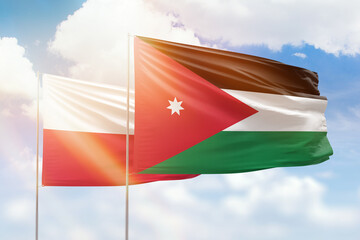 Sunny blue sky and flags of jordan and poland