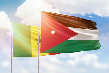 Sunny blue sky and flags of jordan and senegal