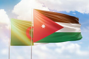 Sunny blue sky and flags of jordan and algeria