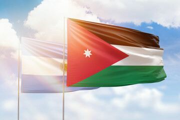 Sunny blue sky and flags of jordan and argentina