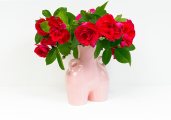 bouquet of fresh red roses in a pink vase on a white background
