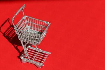Supermarket cart on red background.