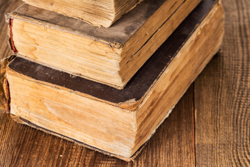stack of three vintage shabby books on an old wooden table.macro. Selective focus.