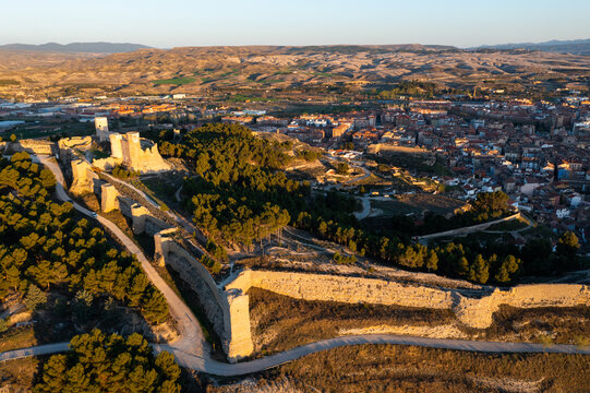 Picturesque aerial view of remains of ancient moorish Ayub Castle with fortification walls on top of green hill above Spanish city 