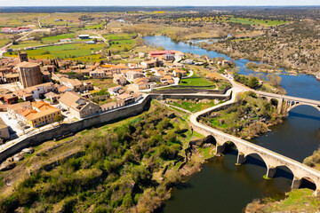 Fototapeta premium Picturesque aerial view of small old Spanish walled township of Ledesma with terracotta tiled roofs of residential houses 