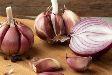 Garlics and onion on cutting board.