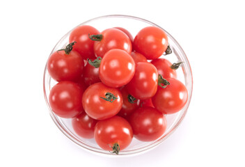 Top view of mini tomatoes in glass bowl isolated on white background.