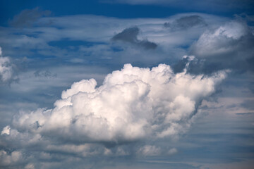 Fototapeta na wymiar Bright landscape of white puffy cumulus clouds on blue clear sky
