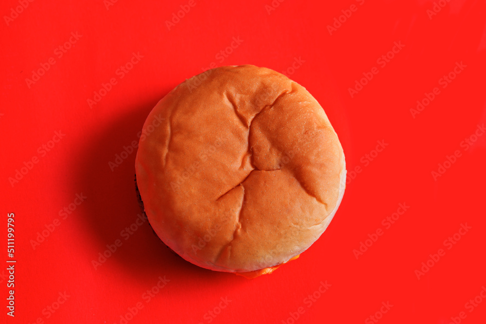 Wall mural cheese burger viewed from above on a red surface from a fast food restaurant