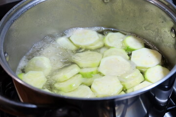 Slices of zucchini in the pot. Boiled vegetables, zucchini in a pan in hot water for blanching. Frozen Food Concept. It is called 
