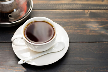 White coffee cup with black coffee or tea. put on desk or reading table - top view