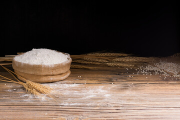 Organic Natural Whole Grain Flour in Sacks and wheat seeds Ears of wheat on an old wooden floor