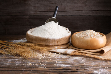 Organic Natural Whole Grain Flour in Sacks and wheat seeds Ears of wheat on an old wooden floor