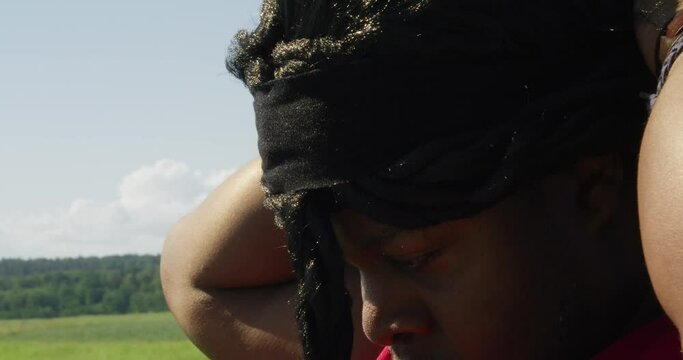 Samson tying his hair as he looks around at green landscape, Biblical character with long dreads, Israelite warrior and judge, black male in old testament, Christian