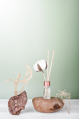  hygge and aromatherapy concept. aroma reed diffuser, cotton bud on white table at home. minimal style composition. winter and autumn mood.