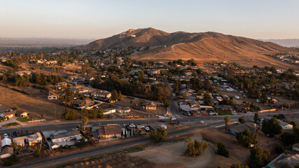 Sunset aerial view of the city and surrounding mountains of Jurupa Valley, California, USA. - obrazy, fototapety, plakaty