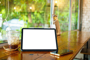 Mockup of digital tablet with empty screen with coffee and smartphone isolate on wooden office desk in coffee shop like the background ,White screen
