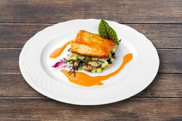 fried salmon fish fillets on a plate on a wooden table