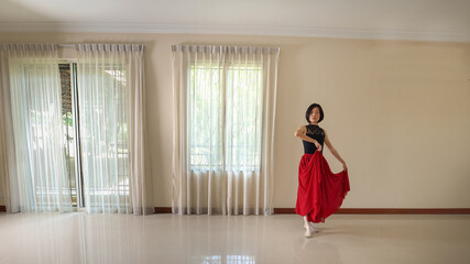 Beautiful Asian woman ballet dancer practice dance wearing tutu at home natural light