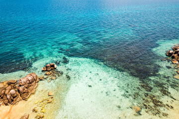 Crystal clear blue water at tropical island, bird's eye view