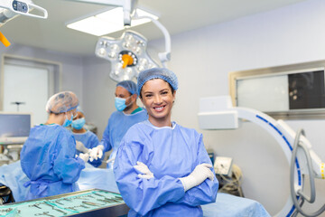 Fototapeta Portrait of female woman nurse surgeon OR staff member dressed in surgical scrubs gown mask and hair net in hospital operating room theater making eye contact smiling pleased happy looking at camera obraz