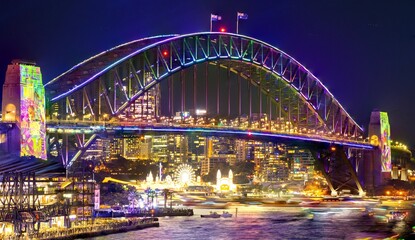 Fototapeta na wymiar Colourful Light show at night on Sydney Harbour NSW Australia. The bridge illuminated with lasers and neon coloured lights 