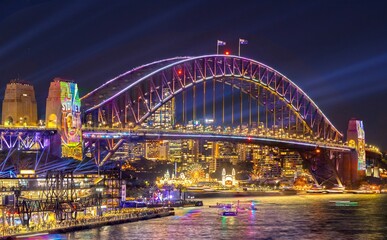 Naklejka na ściany i meble Colourful Light show at night on Sydney Harbour NSW Australia. The bridge illuminated with lasers and neon coloured lights 
