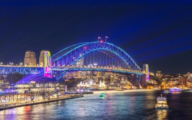 Naklejka na ściany i meble Colourful Light show at night on Sydney Harbour NSW Australia. The bridge illuminated with lasers and neon coloured lights 